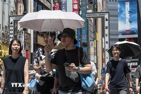 Người dân di chuyển dưới trời nắng nóng tại Tokyo, Nhật Bản ngày 30/7/2023. (Ảnh: AFP/TTXVN)