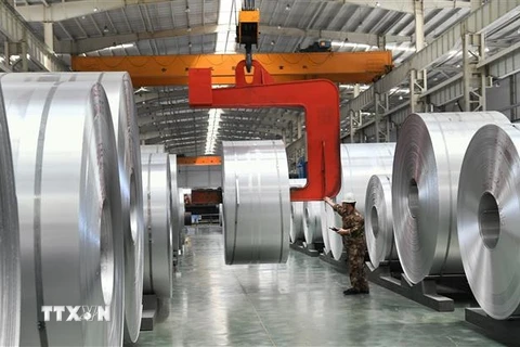 Công nhân vận hành các cuộn nhôm tại nhà máy ở Châu Bình, tỉnh Sơn Đông, Trung Quốc. (Ảnh: AFP/TTXVN)