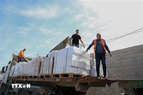 Công nhân bốc dỡ hàng cứu trợ gửi đến Dải Gaza qua cửa khẩu Rafah ngày 21/10/2023. (Ảnh: THX/TTXVN)