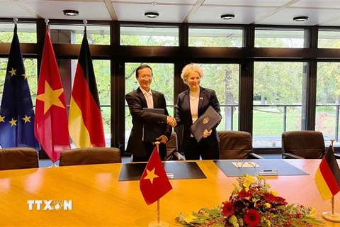 Tiến sỹ Phạm Hoàng Mai, Vụ trưởng Vụ Kinh tế Đối ngoại, Bộ Kế hoạch và Đầu tư và bà Gisela Hammerschmidt, Vụ trưởng Vụ châu Á, Cao ủy viên đặc trách châu Á của BMZ ký thỏa thuận. (Ảnh: Mạnh Hùng/TTXVN)