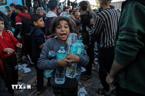 Trẻ em Palestine nhận lương thực cứu trợ tại Khan Younis, Dải Gaza ngày 21/11/2023. (Nguồn: AFP/TTXVN)