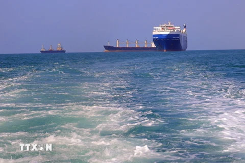Tàu chở hàng (phải), bị lực lượng Houthi bắt giữ, trên đường về cảng tỉnh Hodeida (Yemen), ngoài khơi Biển Đỏ, ngày 22/11/2023. (Ảnh: AFP/TTXVN)