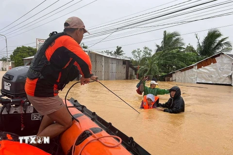 Sơ tán người dân khỏi khu vực ngập lụt ở thị trấn Catarman, miền Trung Philippines. (Ảnh: AFP/TTXVN)