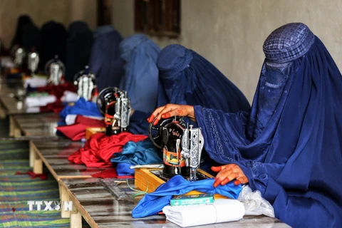Phụ nữ Afghanistan làm việc tại xưởng may ở thành phố Jalalabad ngày 1/12/2022. (Ảnh: AFP/TTXVN)