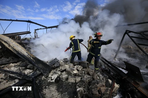 Lính cứu hỏa dập lửa tại một nhà máy sau vụ không kích của Israel xuống thị trấn Ghazieh, Liban ngày 20/2/2024. (Ảnh: THX/TTXVN)