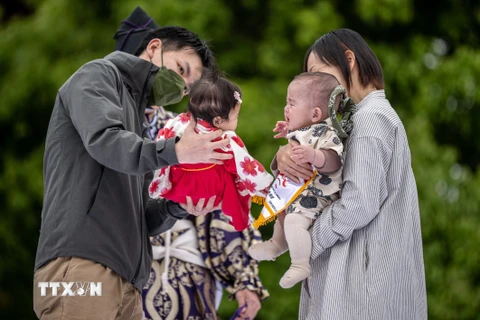 Cha mẹ cho các con tham gia một trò chơi ở Tokyo, Nhật Bản ngày 22/4/2023. (Ảnh: AFP/TTXVN)