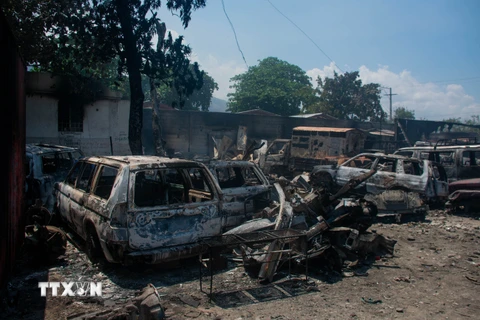 Các phương tiện bị đốt cháy trong bạo lực băng nhóm ở thủ đô Port-au-Prince, Haiti, ngày 25/3/2024. (Ảnh: AFP/TTXVN)