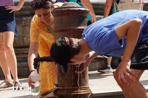 Người dân uống nước để giải nhiệt tại Rome, Italy, ngày 18/7/2023. (Ảnh: THX/TTXVN)
