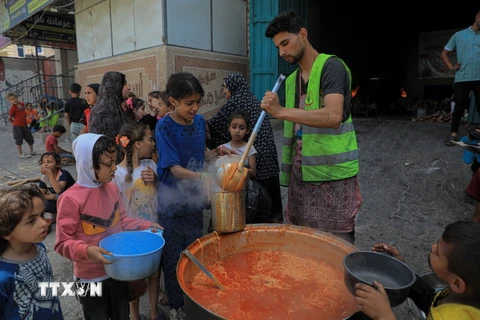 Các em nhỏ nhận thực phẩm cứu trợ tại thành phố Rafah, Dải Gaza, ngày 28/4/2024. (Ảnh: THX/TTXVN)