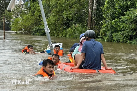 Cán bộ, chiến sỹ Ban Chỉ huy quân sự thành phố Phú Quốc cùng với lực lượng tại địa phương ứng cứu, sơ tán người dân đến nơi an toàn. (Ảnh: TTXVN phát)