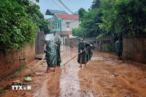 Cán bộ, chiến sĩ Ban Chỉ huy quân sự huyện Sơn Động giúp dân dọn dẹp môi trường sau khi lũ rút. Ảnh: TTXVN phát