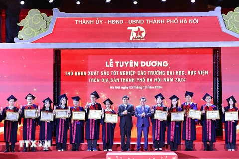 Ông Nguyễn Đắc Vinh, Ủy viên Trung ương Đảng, Chủ nhiệm Ủy ban Văn hóa, Giáo dục của Quốc hội và ông Nguyễn Văn Phong, Phó Bí thư Thành ủy Hà Nội trao Bằng khen của Chủ tịch Ủy ban Nhân dân Thành phố cho các thủ khoa xuất sắc tiêu biểu. (Ảnh: Minh Đức/TTXVN)