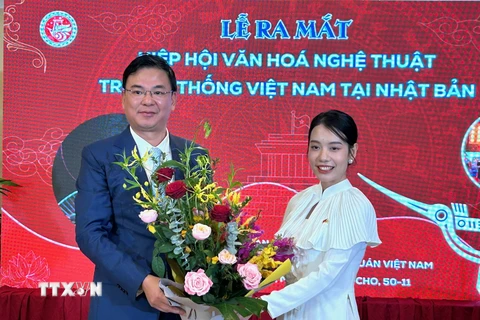 Đại sứ Việt Nam tại Nhật Bản Phạm Quang Hiệu chúc mừng bà Đỗ Khánh Hân, Chủ tịch Hiệp hội Văn hóa Nghệ thuật truyền thống Việt Nam tại Nhật Bản. (Ảnh: Nguyễn Tuyến/TTXVN)