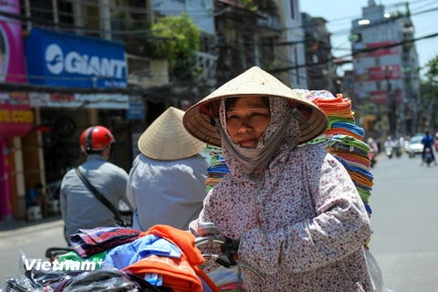 Người lao động oằn mình trong cái nóng bỏng rát giữa Thủ đô. (Ảnh: Minh Sơn/Vietnam+)