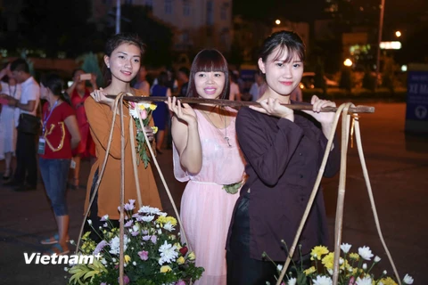 Trong chương trình này, các bạn trẻ sẽ được thử sức mình khi hóa thân vào các cô gái điệu đàng với gánh hàng hoa trên phố. (Ảnh: PV/Vietnam+)