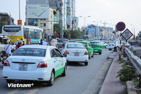 Dạo một vòng quanh Hà Nội không khó để bắt gặp cảnh taxi rồng rắn dừng đỗ trái phép. Thậm chí ngay dưới biển báo cấm dừng đỗ. (Ảnh: Minh Sơn/Vietnam+)