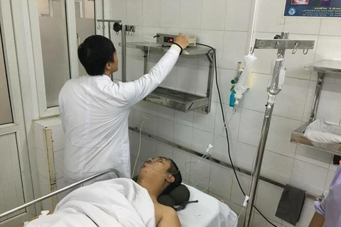 Thượng úy Nguyễn Quốc Đạt đang trong tình trạng bị chấn thương nặng, khó thở. Các bác sỹ đa khoa đang tiến hành đưa đi chụp chiếu. (Ảnh: PV/Vietnam+)