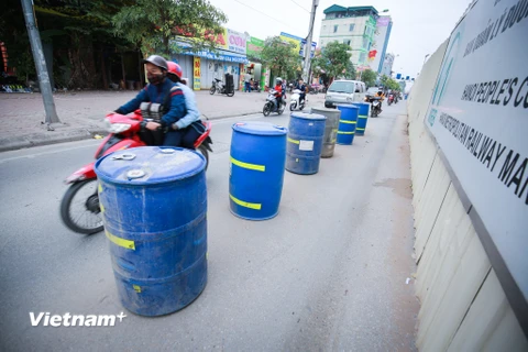 Những chiếc thùng phuy được làm thành dải phân cách giúp người đi đường 'dễ dàng' đi lại, nhất là vào giờ cao điểm. (Ảnh: Minh Sơn/Vietnam+)