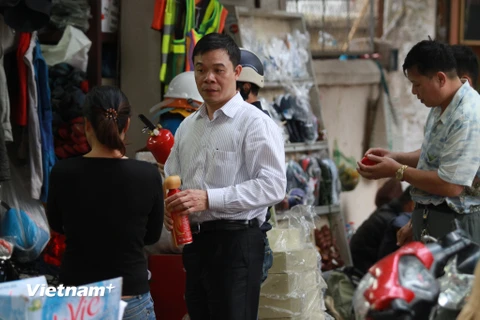 Cánh tài xế chen nhau đi mua bình cứu hỏa cho xe ôtô. (Ảnh: Minh Sơn/Vietnam+)