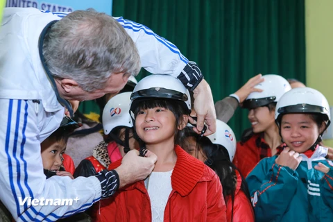 Đại sứ Mỹ vui mừng khi tận tay trao những chiếc mũ bảo hiểm cho những em nhỏ tại làng trẻ SOS. (Ảnh: PV/Vietnam+)