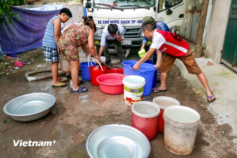 Sau khi nguồn nước sạch bị mất được 9 ngày, rất nhiều hộ dân đã được 'giải cứu' bằng một xe bồn chở nước sạch của công ty cấp nước Hà Nội. (Ảnh: Minh Sơn/Vietnam+)
