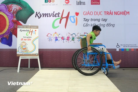 Các bạn nhỏ tại Hà Nội đã có một trải nghiệm đáng nhớ khi đóng vai người khuyết tật ngồi xe lăn để cảm nhận được những khó khăn của họ trong cuộc sống. (Ảnh: Minh Sơn/Vietnam+)
