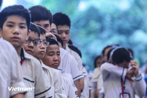 Hàng trăm học sinh và thầy cô trường Lương Thế Vinh đã đồng thanh bài hát truyền thống nhà trường để tiễn biệt nhà giáo Văn Như Cương. (Ảnh: Minh Sơn/Vietnam+) 