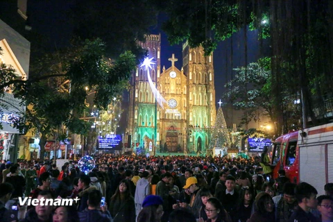 Đêm Giáng sinh trùng đúng vào dịp Chủ Nhật ngày nghỉ nên ngay từ chập tối, hàng vạn người dân Thủ đô đã đổ về các khu vực diễn ra lễ hội như Nhà thờ lớn, phố đi bộ Hồ Gươm. (Ảnh: Minh Sơn/Vietnam+)