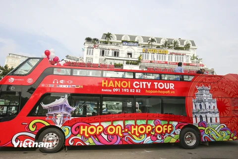 Sáng 30/5, 3 chiếc xe buýt 2 tầng, mui trần màu đỏ phục vụ du lịch đã chính thức được lăn bánh trong sự chờ đón của rất nhiều người dân Thủ đô. (Ảnh: PV/Vietnam+) 