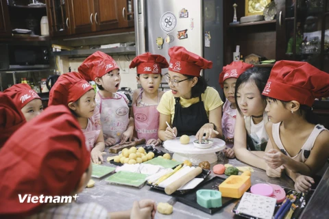 Mỗi dịp Trung thu, trẻ em lại hào hứng được rước đèn, phá cỗ với những chiếc bánh nướng, bánh dẻo thơm ngon. Tuy nhiên không phải bé nào cũng hiểu được ý nghĩa và biết cách làm món bánh truyền thống này. (Ảnh: Minh Sơn/Vietnam+)