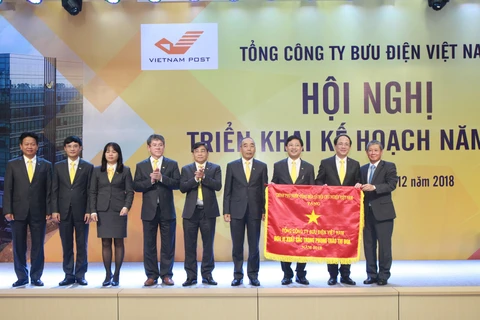 Thứ trưởng Bộ Thông tin và Truyền thông Nguyễn Thành Hưng (phải) thừa ủy quyền của Thủ tướng Chính phủ lên trao Cờ thi đua cho tập thể VietnamPost. (Nguồn: VNP) 