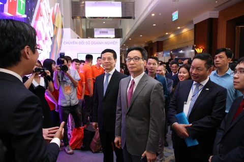 Phó Thủ tướng Chính phủ Vũ Đức Đam tham quan gian hàng của FPT tại Vietnam ICT Summit 2019. (Ảnh: Minh Sơn/Vietnam+)