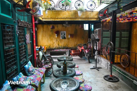 Ẩn sâu trong một ngõ nhỏ trên con phố Hàng Tre tấp nập, anh Nguyễn Văn Thơ, 35 tuổi, đã tạo ra một không gian sống động từ những đầu máy cày cũ, máy tuốt, bánh xe, bóng đèn đến những chai thủy tinh. (Ảnh: Vietnam+)