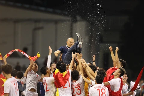 Cầu thủ Việt Nam tung hô HLV Park Hang Seo sau chiến thắng lịch sử. (Ảnh: Hoàng Linh/TTXVN)
