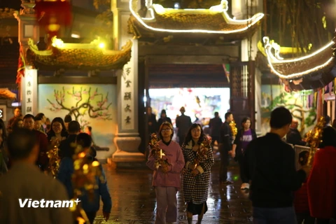 Sau thời khắc chuyển giao giữa năm cũ và năm mới, rất đông người dân Hà Nội đến chùa Hà (Cầu Giấy, Hà Nội) để thắp hương, lễ phật, xin lộc, cầu mong năm mới an lành. (Ảnh: Minh Sơn/Vietnam+)
