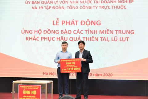 Phó Tổng Giám đốc Tập đoàn VNPT (bên phải) trao tượng trưng 10 tỷ đồng do cán bộ nhân viên VNPT chung tay để hỗ trợ đồng bào miền Trung. (Ảnh: VNPT) 