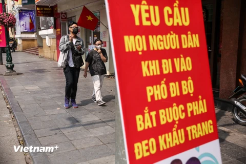 Tình hình COVID-19 tại Hà Nội đang diễn biến phức tạp nên người dân Thủ đô đã chủ động tăng cường các biện pháp chống dịch, đeo khẩu trang và hạn chế đi ra ngoài dịp cuối tuần. (Ảnh: Minh Sơn/Vietnam+) 