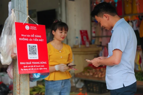 Người dân có thể dễ dàng thanh toán một bó rau hoặc một túi hoa quả chỉ bằng việc quét mã QR hoặc chuyển tiền qua số điện thoại. (Ảnh: Minh Sơn/Vietnam+)