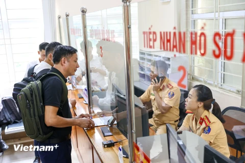 Sáng 15/8 tại Cơ sở đăng ký xe số 2 (Láng Thượng, Đống Đa, Hà Nội) trong ngày đầu định danh biển số xe, nhiều người dân đã bắt đầu đến làm thủ tục sang tên đổi chủ, thu hồi biển số, đăng ký mới. (Ảnh: Minh Sơn/Vietnam+)
