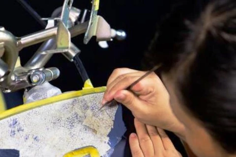 Nghệ nhân chế tác chiếc Vespa bằng kỹ thuật cẩn trứng sơn mài truyền thống. (Ảnh: QH)