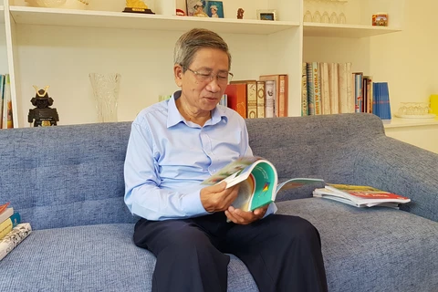 Giáo sư Nguyễn Minh Thuyết cầm trên tay bản mẫu của sách "Cánh diều" Tiếng Việt lớp 1, tập hai