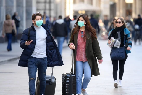 Người dân đeo khẩu trang phòng dịch viêm đường hô hấp cấp COVID-19 tại Milan, Italy ngày 24/2/2020. (Nguồn: THX/TTXVN)