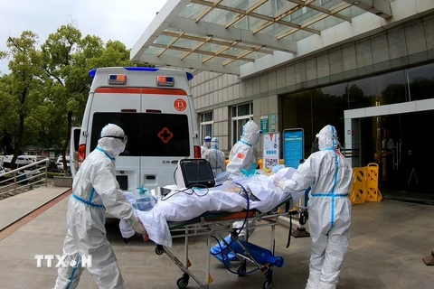 Nhân viên y tế chuyển bệnh nhân nhiễm COVID-19 tới bệnh viện ở Vũ Hán, tỉnh Hồ Bắc, Trung Quốc, ngày 11/4/2020. Ảnh: THX/TTXVN