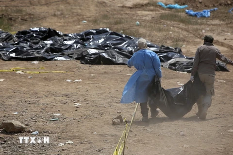 Lực lượng an ninh chuyển thi thể các nạn nhân được cho là bị IS hành quyết tại trại Speicher ở Tikrit, Iraq ngày 12/4/2015. (Nguồn: AFP/TTXVN)