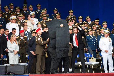 Lực lượng an ninh Venezuela bảo vệ Tổng thống Nicolas Maduro khi xảy ra vụ tấn công bằng thiết bị bay không người lái có gắn thuốc nổ tại Lễ kỷ niệm 81 năm ngày thành lập lực lượng Phòng vệ quốc gia ở Caracas ngày 4/8. (Nguồn: THX/ TTXVN)
