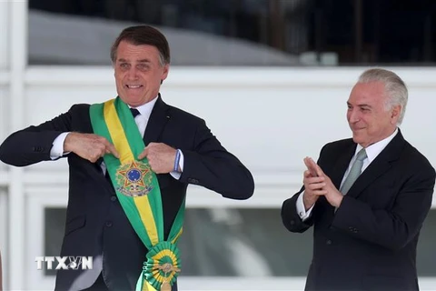 Tổng thống mãn nhiệm của Brazil Michel Temer (phải) trao khăn choàng biểu tượng cho Tổng thống đắc cử Jair Bolsonaro (trái) tại lễ tuyên thệ nhậm chức ở Brasilia ngày 1/1/2019. (Nguồn: THX/TTXVN)
