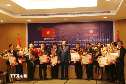 Bộ trưởng Bộ Lao động-Thương binh và Xã hội Việt Nam Đào Ngọc Dung trao tặng Huân chương Hữu nghị cho tập thể của Bộ Lao động và Phúc lợi xã hội Lào. (Nguồn: Xuân Tú/TTXVN)