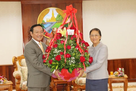 Đại sứ Nguyễn Bá Hùng (trái) chuyển hoa của Chủ tịch Quốc hội Việt Nam chúc mừng Chủ tịch Quốc hội Lào Pany Yathotou nhân dịp Bunpimay Lào. (Nguồn: Xuân Tú – Thu Phương/TTXVN)