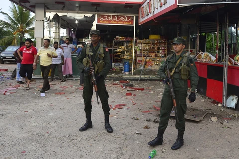 Lực lượng an ninh Sri Lanka gác bên ngoài một cửa hàng bị đập phá trong vụ đụng độ nhằm vào người Hồi giáo ở Minuwangoda ngày 14/5. (Ảnh: AFP/TTXVN)