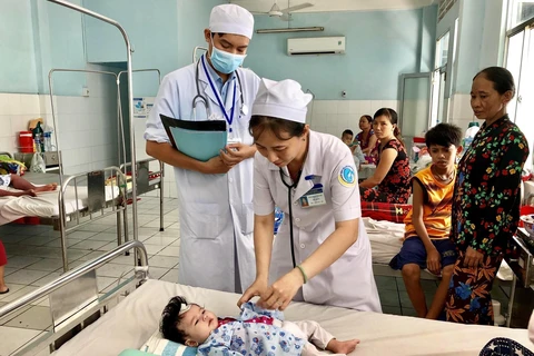 Các bác sĩ Bệnh viện Sản nhi An Giang thăm khám cho một bệnh nhi mắc sốt xuất huyết. (Ảnh: Thanh Sang/TTXVN)